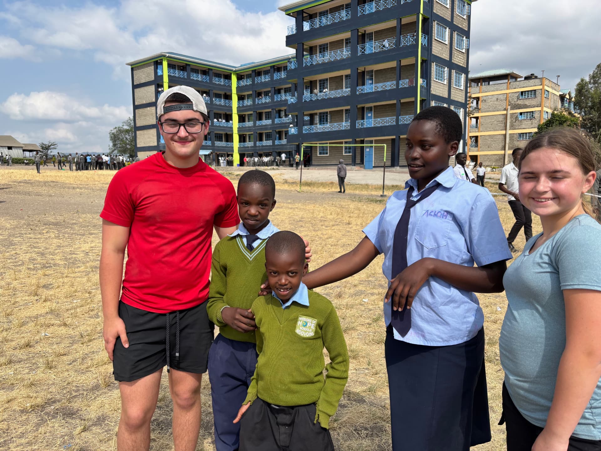 Remi with students on the school field